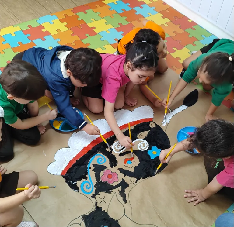Crianças pintando em grupo na Green Kids School